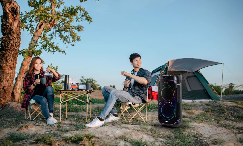 Foto 1 - Dua anak muda bersantai sambil menikmati alunan musik dari portable party speaker Sharp