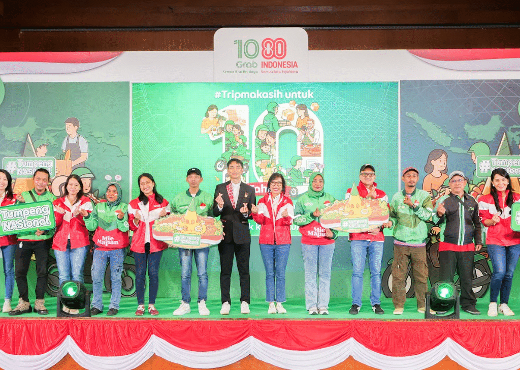 Jajaran Manajemen Grab Indonesia berfoto bersama dengan perwakilan MURI dan perwakilan Mitra Pengemudi pada puncak perayaan “1080 Grab Indonesia: Semua Bisa Berdaya, Semua Bisa Sejahtera’ di Padepokan Pencak Silat Indonesia TMII, Jakarta (15/08).
