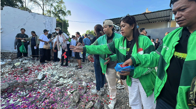 Sejumlah Mitra Pengemudi Grab Bali yang mengenal dekat Bapak Rio dan Timothy mengikuti prosesi tabur bunga dengan anggota keluarga yang ditinggalkan sebagai bentuk penghormatan terakhir di Perumahan Permata Residence, Desa Mengwitani, Badung, Bali (21/9/2025).
